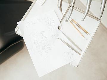 Behandlungsstuhl auf dem Kinderzeichnungen liegen