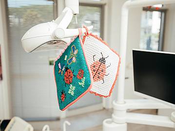 Bunte Topflappen mit Marienkäfern hängen von der Behandlungsleuchte